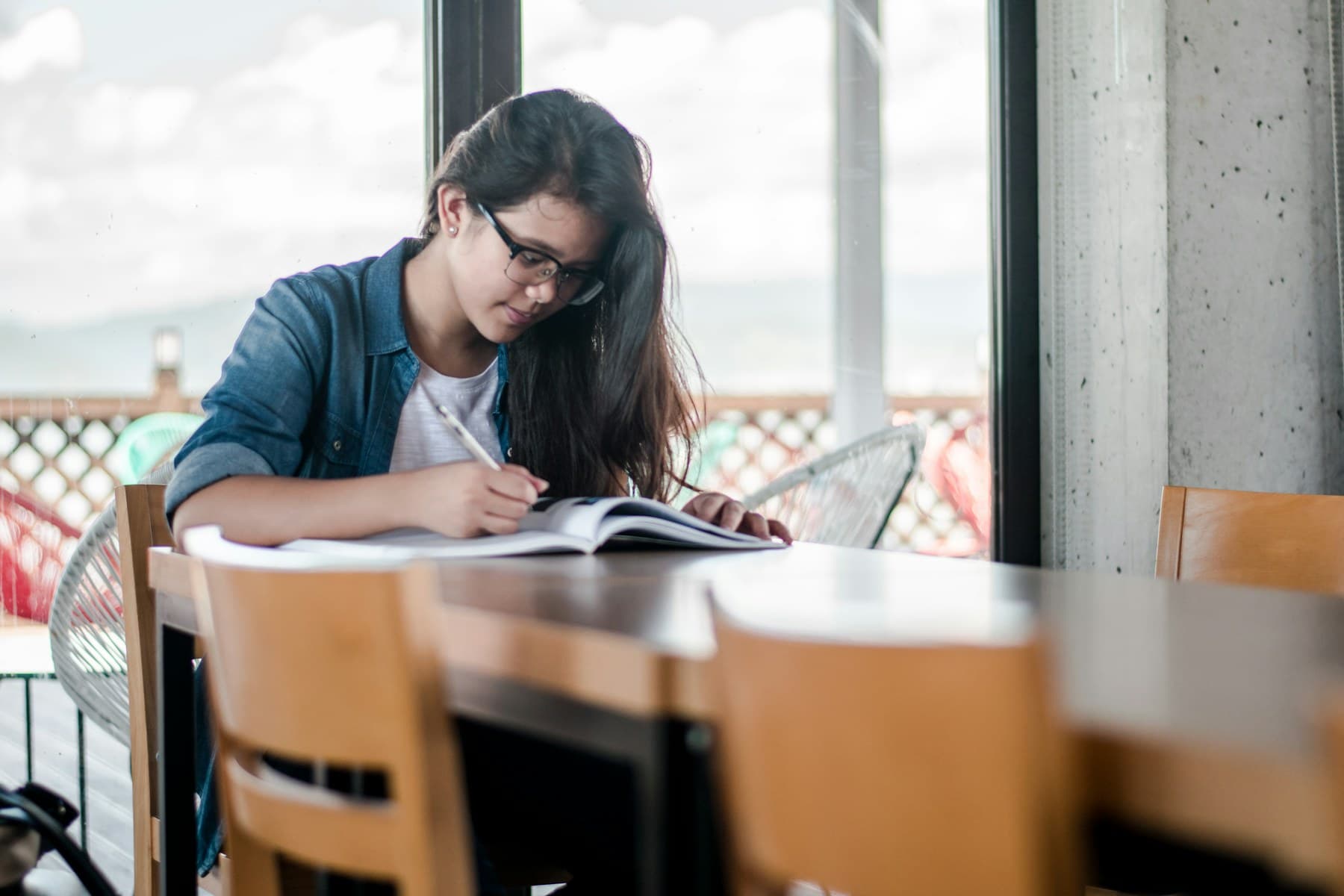 A student reviewing a book and writing notes